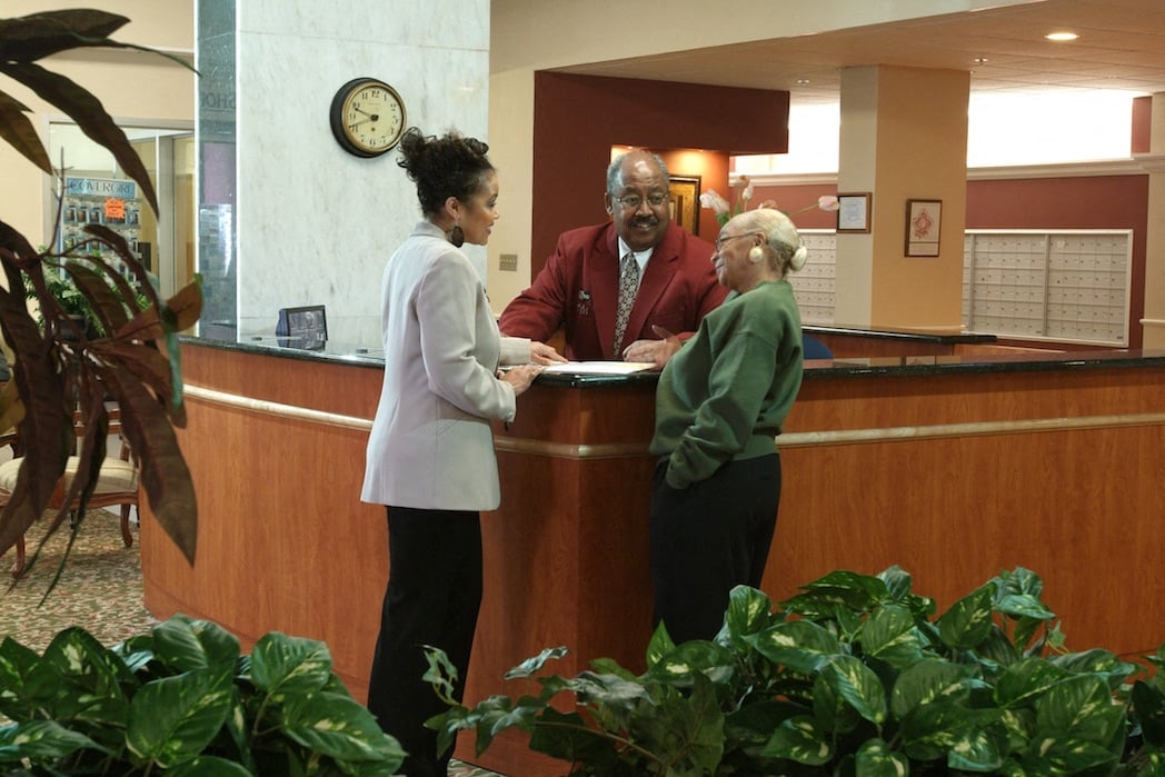 Lobby with the concierge talking to residents.